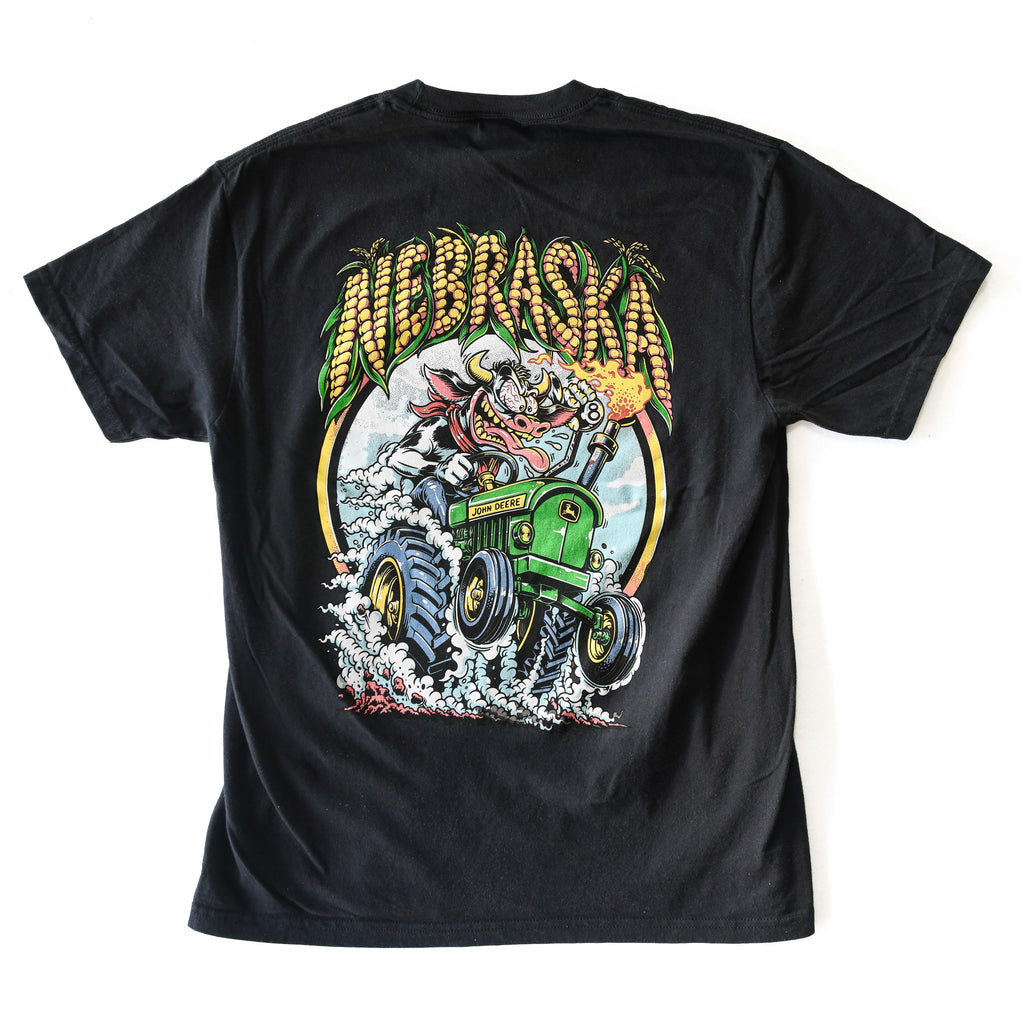 Back of black Nebraska Corn Fiend tee with wild cow driving a green tractor