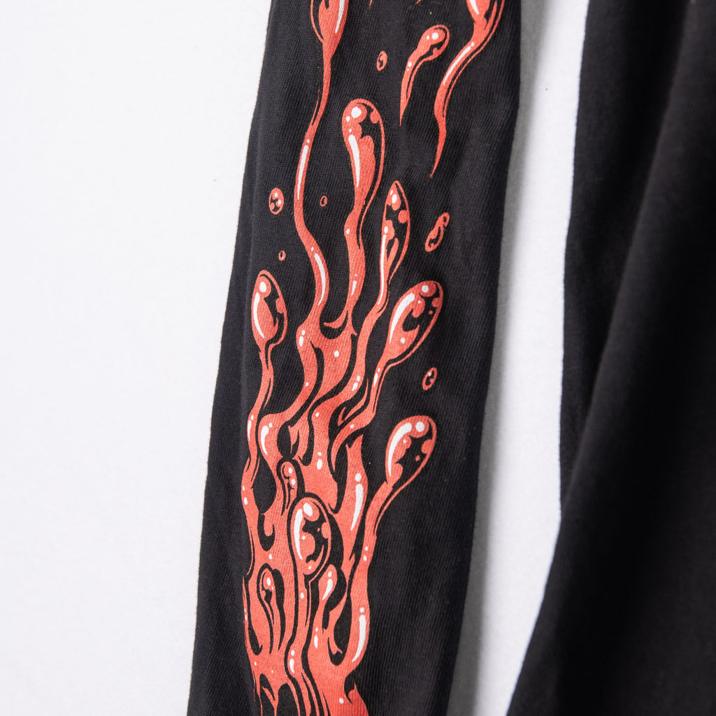 Black shirt sleeve detail with coral ink splatter graphic