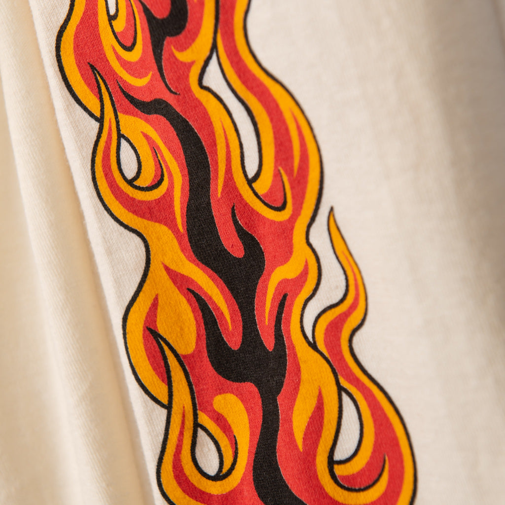 Close-up of red and yellow flames screen printed on cream long sleeve